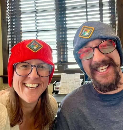 Two Rocky Mountain Catastrophe & Restoration team members wearing original company logo beanies