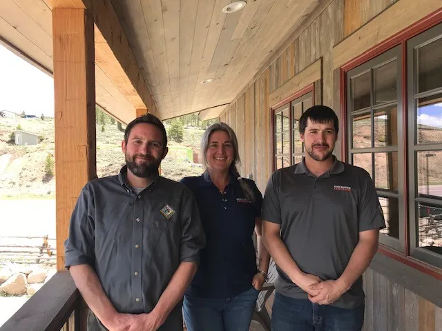 Three Rocky Mountain Catastrophe & Restoration team members on the porch of the Tabernash office