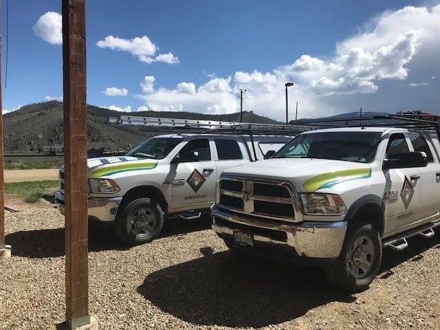 Rocky Mountain Catastrophe & Restoration trucks parked beneath the hills of Grand County